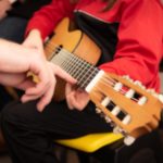 image of hand teaching guitar