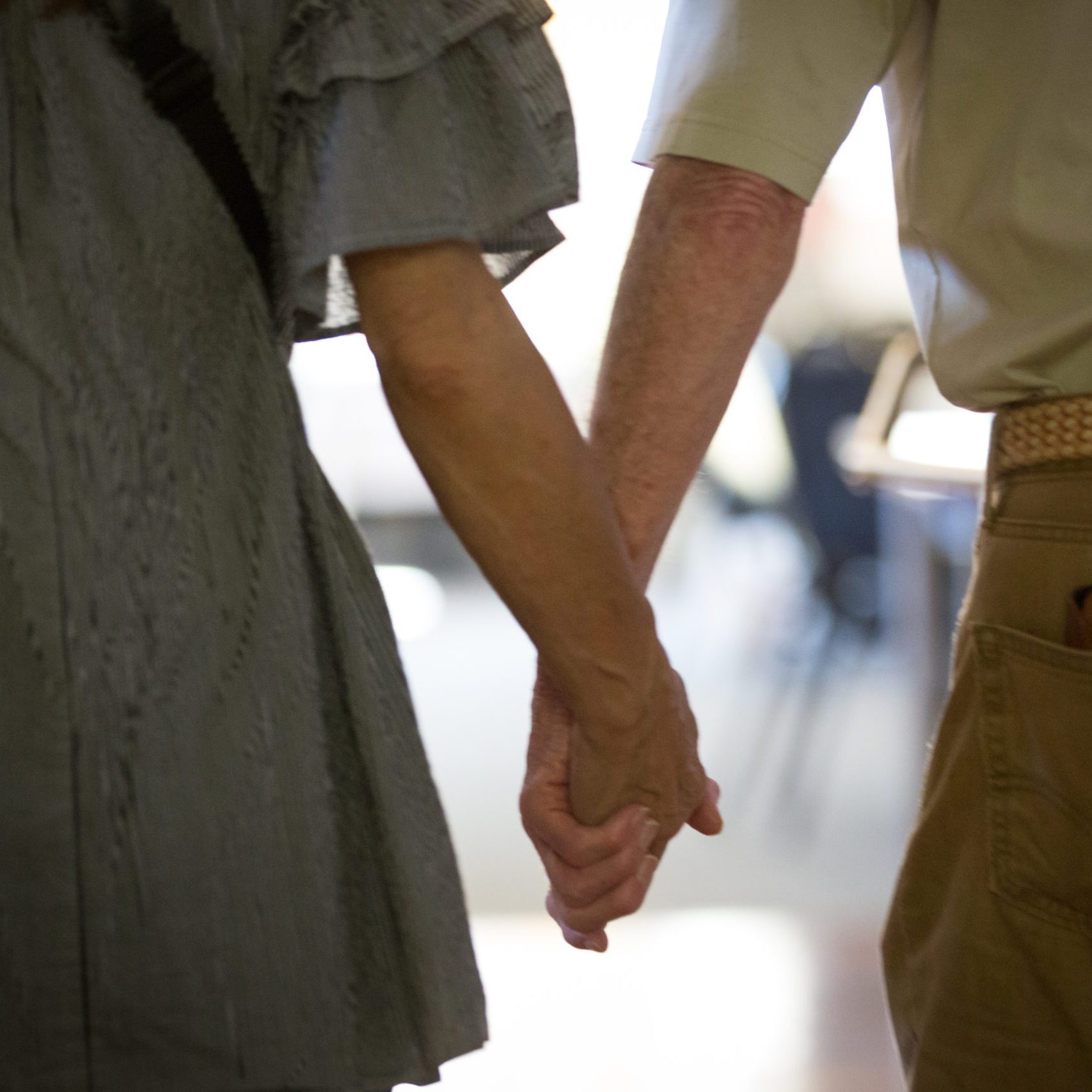 An older adult couple holding hands - closeup