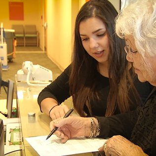 Senior receives assistance checking in for medical appointment