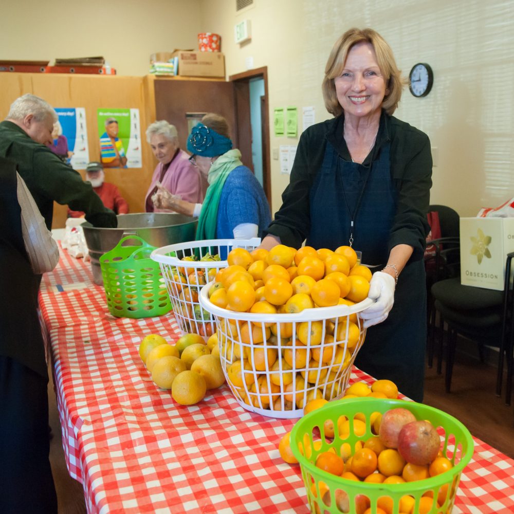 Vivalon Food Pantry volunteer with fresh oranges